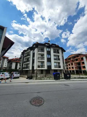 a building on the side of a city street at Mila Apartment in Bansko