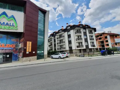 a white car parked in front of a building at Mila Apartment in Bansko