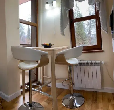 a kitchen with two stools and a table in a room at Ski to door at Mountain View 1BR condo Bansko in Bansko