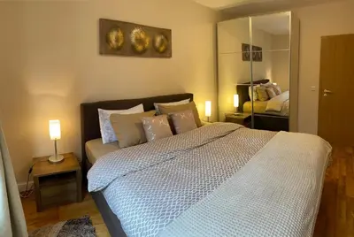 a bedroom with a bed with pillows and a mirror at Ski to door at Mountain View 1BR condo Bansko in Bansko