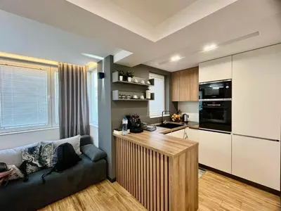 a living room with a couch and a kitchen at Апартамент Мегилукс 2 in Blagoevgrad