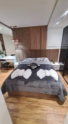 a bedroom with a large bed with two white towels at Апартамент Мегилукс 2 in Blagoevgrad