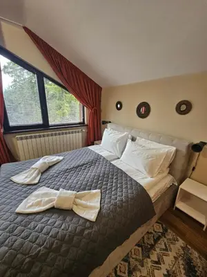 a bedroom with a bed with a bow tie on it at Rustic Mountain Apartment - A55 in Borovets