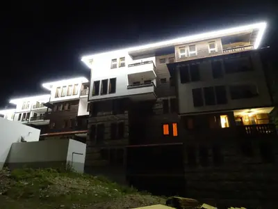a tall building at night with lights on at APARTMENT Darsi in Pamporovo