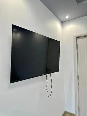 a flat screen tv hanging on a white wall at Central Vista Apartment by MIT in Sofia