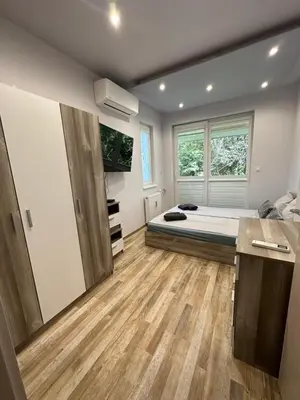 a bedroom with a bed and a tv on the wall at Central Vista Apartment by MIT in Sofia