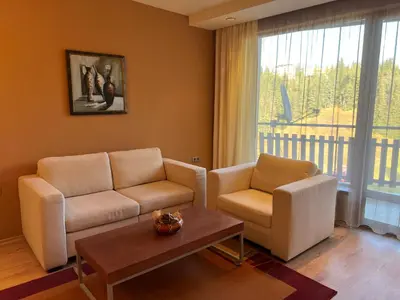 a living room with a couch and two chairs and a table at St Trifon Guests Apartments in Pamporovo