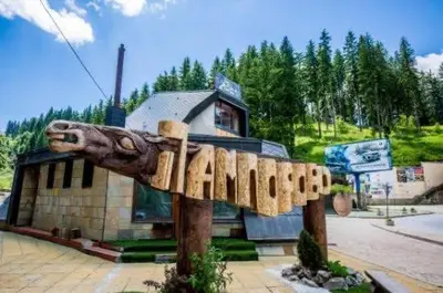 a wooden sign in front of a building at St Trifon Guests Apartments in Pamporovo