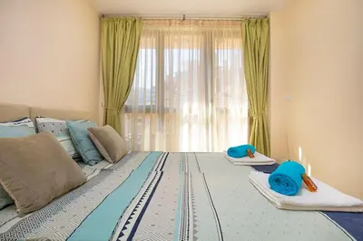 a bedroom with a large bed with blue pillows on it at 2BR apartment ,10 minutes walk to TOP Center in Plovdiv