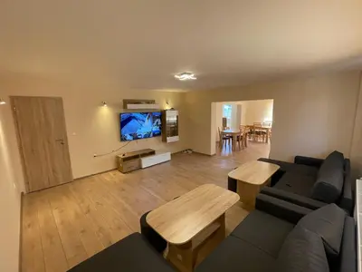a living room with a couch and a flat screen tv at Villa Stoyanovata Kashta in Samokov