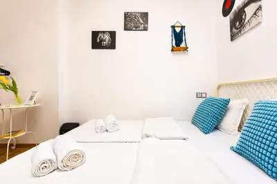 a white room with two beds and pictures on the wall at House Of History , Rooms in the Main Street Plovdiv in Plovdiv