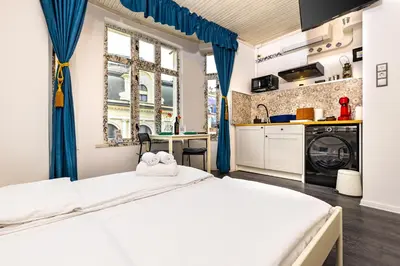 a bedroom with two beds and a kitchen with a window at House Of History , Rooms in the Main Street Plovdiv in Plovdiv