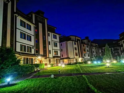a group of buildings at night with lights at Bansko Downtown R LUX apartment in Bansko