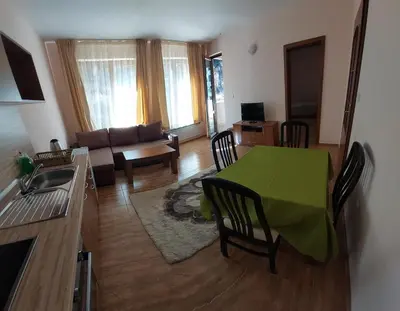 a living room with a green table and a couch at Апартамент Николови Пампорово in Pamporovo