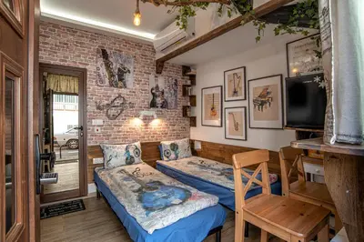 a bedroom with two beds and a brick wall at The Music House - Exclusive Studio in the Heart of Sofia by Flat Mаnager in Sofia