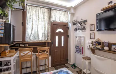 a living room with a wooden door and a tv at The Music House - Exclusive Studio in the Heart of Sofia by Flat Mаnager in Sofia