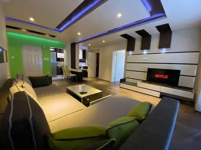 a living room with a couch and a tv at Modern 1BR Apartment with Garden View & Free street parking in Plovdiv