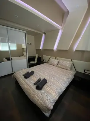 a bedroom with a bed with two black objects on it at Modern 1BR Apartment with Garden View & Free street parking in Plovdiv