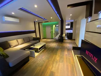 a living room with a couch and a tv at Modern 1BR Apartment with Garden View & Free street parking in Plovdiv
