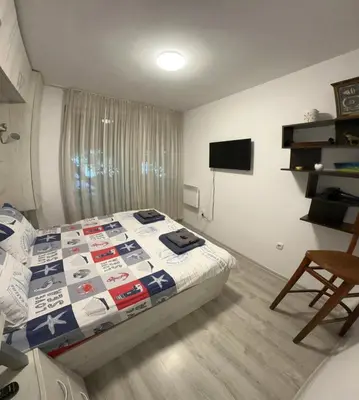 a bedroom with a bed and a television in it at Eli's cozy place in Sofia