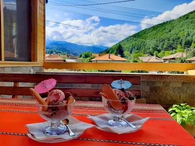 a table with two wine glasses on top of a table at Kovacha Guest House in Raduil