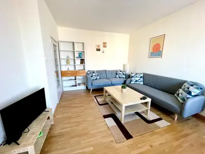 a living room with a blue couch and a tv at 2-BDR Flat Near the Mall, Spacious & Cozy by Flat Mаnager in Sofia