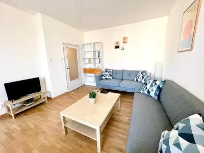 a living room with a blue couch and a table at 2-BDR Flat Near the Mall, Spacious & Cozy by Flat Mаnager in Sofia