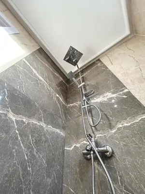 a shower in a bathroom with a marble floor at Bulgarane House in Govedartsi
