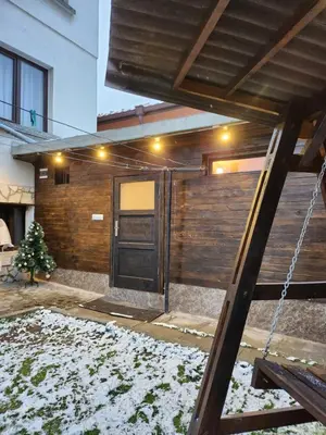 a front door of a house with snow on the ground at Bulgarane House in Govedartsi
