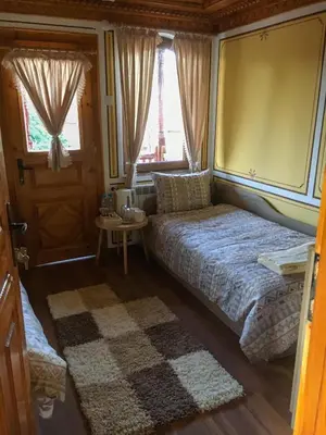 a small bedroom with a bed and a window at Стаи за гости Бащино огнище in Koprivshtitsa