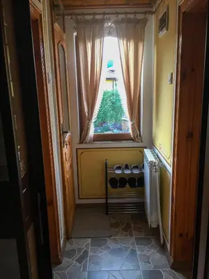 a hallway with a window with a christmas tree at Стаи за гости Бащино огнище in Koprivshtitsa