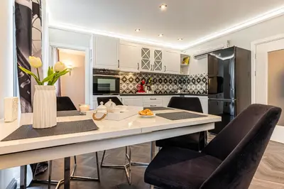 a kitchen with a table with chairs and a counter top at Апартаменти Стефани in Plovdiv