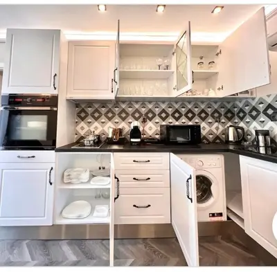 a kitchen with white cabinets and a washer and dryer at Апартаменти Стефани in Plovdiv