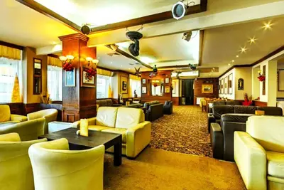 a hotel lobby with couches and tables and chairs at Snow Line Suites SLS in Bansko