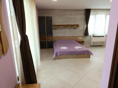 a bedroom with a purple bed with two towels on it at Lime House, Kyustendil in Kyustendil