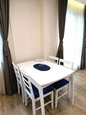 a white table and chairs in a room with windows at Lime House, Kyustendil in Kyustendil