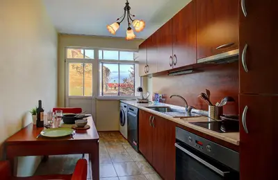 a kitchen with wooden cabinets and a table and a sink at 1BD Nest in the heart of a traditional Sofia by Flat Mаnager in Sofia