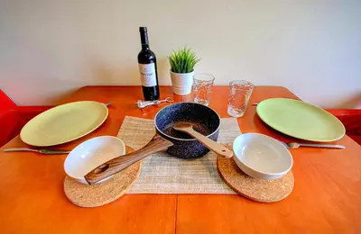 a table with plates and bowls and a bottle of wine at 1BD Nest in the heart of a traditional Sofia by Flat Mаnager in Sofia