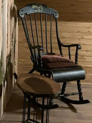 a black rocking chair sitting on a porch at The Forest Villa Borovets by BookVillaBG in Borovets