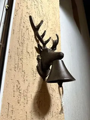 a bell hanging on the side of a wall at The Forest Villa Borovets by BookVillaBG in Borovets