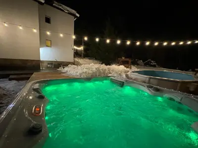 a swimming pool with green water at night at The Forest Villa Borovets by BookVillaBG in Borovets