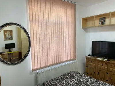 a room with a window with a mirror and a television at Дом за Гости Осогово in Kyustendil