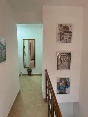 a hallway with a mirror and pictures on the wall at Дом за Гости Осогово in Kyustendil