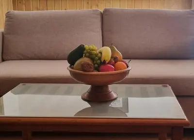 a bowl of fruit on a coffee table in front of a couch at Pirin Golf Private Apartments & Studios in Razlog