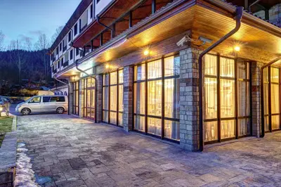 a building with large windows and a car parked outside at Complex Silver Hills in Smolyan
