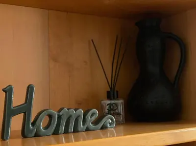 a wooden shelf with a home sign and a vase at Cozy mountain apartament near the Gondola lift in Bansko
