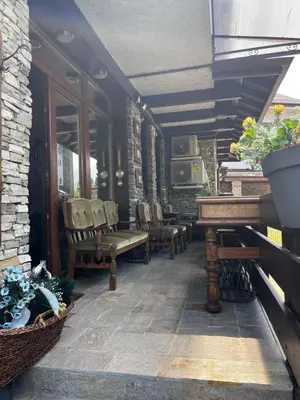 a porch with chairs and a piano on a house at Cozy mountain apartament near the Gondola lift in Bansko