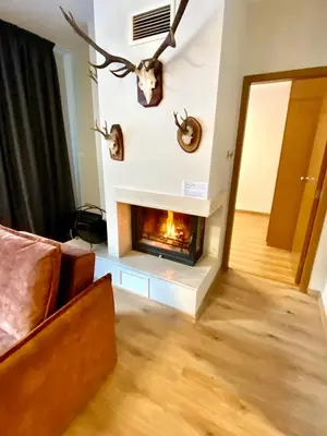 a living room with a fireplace withanimal heads on the wall at Antonovi Apartments 1 in hotel Laplandia in Pamporovo