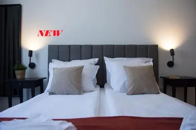 a bedroom with a bed with white sheets and pillows at Antonovi Apartments 1 in hotel Laplandia in Pamporovo