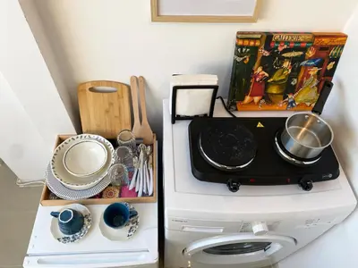 a kitchen with a washing machine with a stack of dishes at LK17 - Loft in the Center in Sofia
